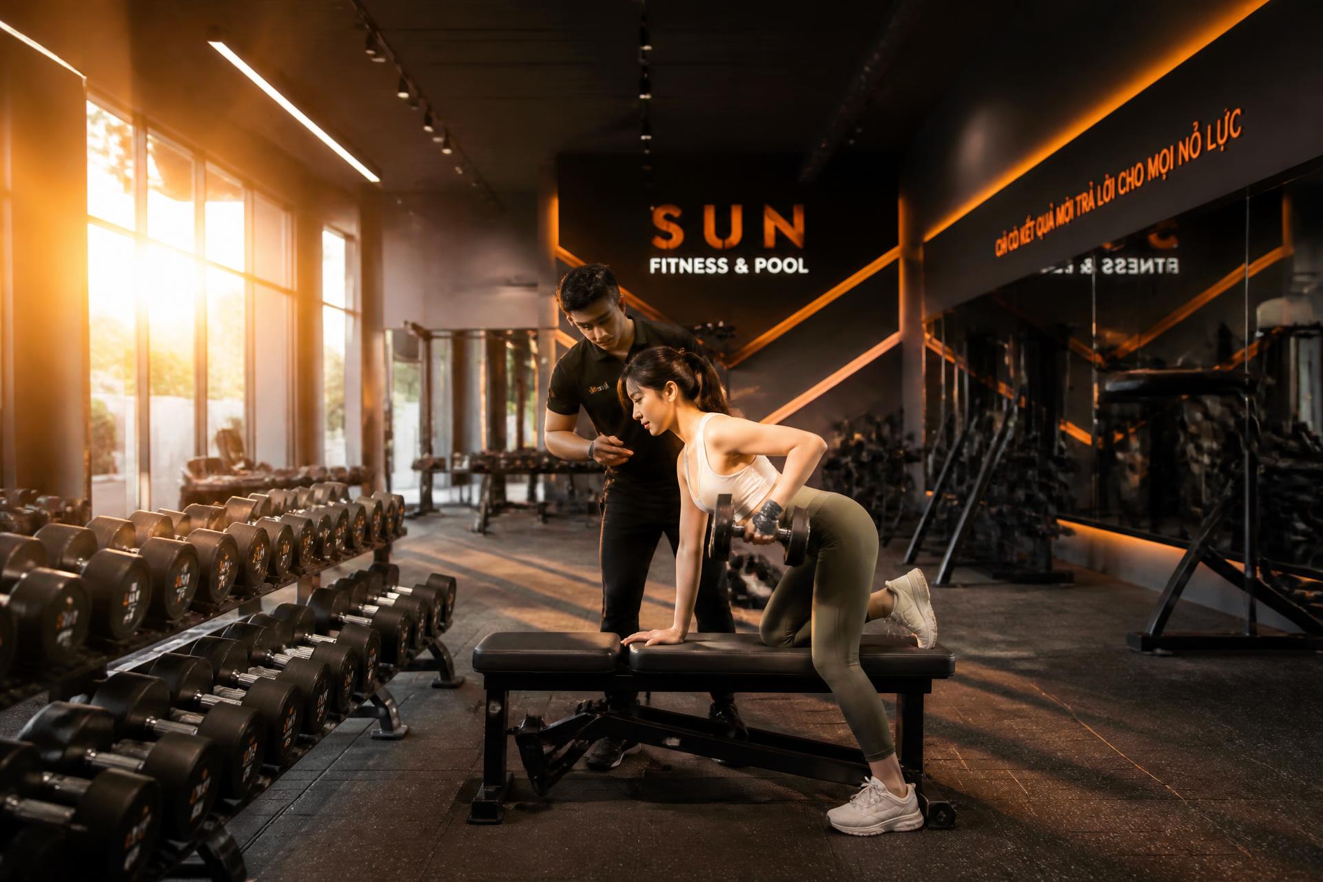 Không gian tập luyện hiện đại tại ME GYM với huấn luyện viên đang hướng dẫn hội viên